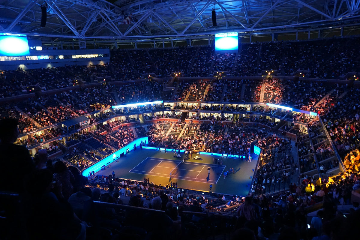 Arthur Ashe Stadium at night, spectators filling the tiers around the court